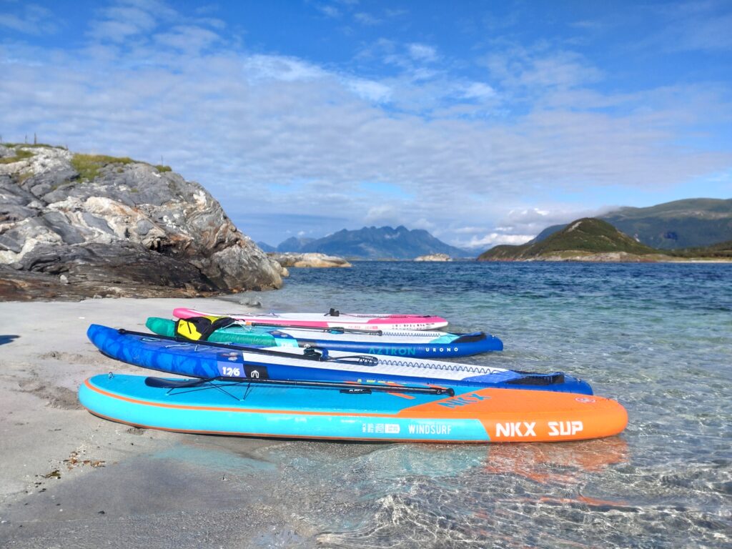 Stand up padle boards liggende på en strand. Foto