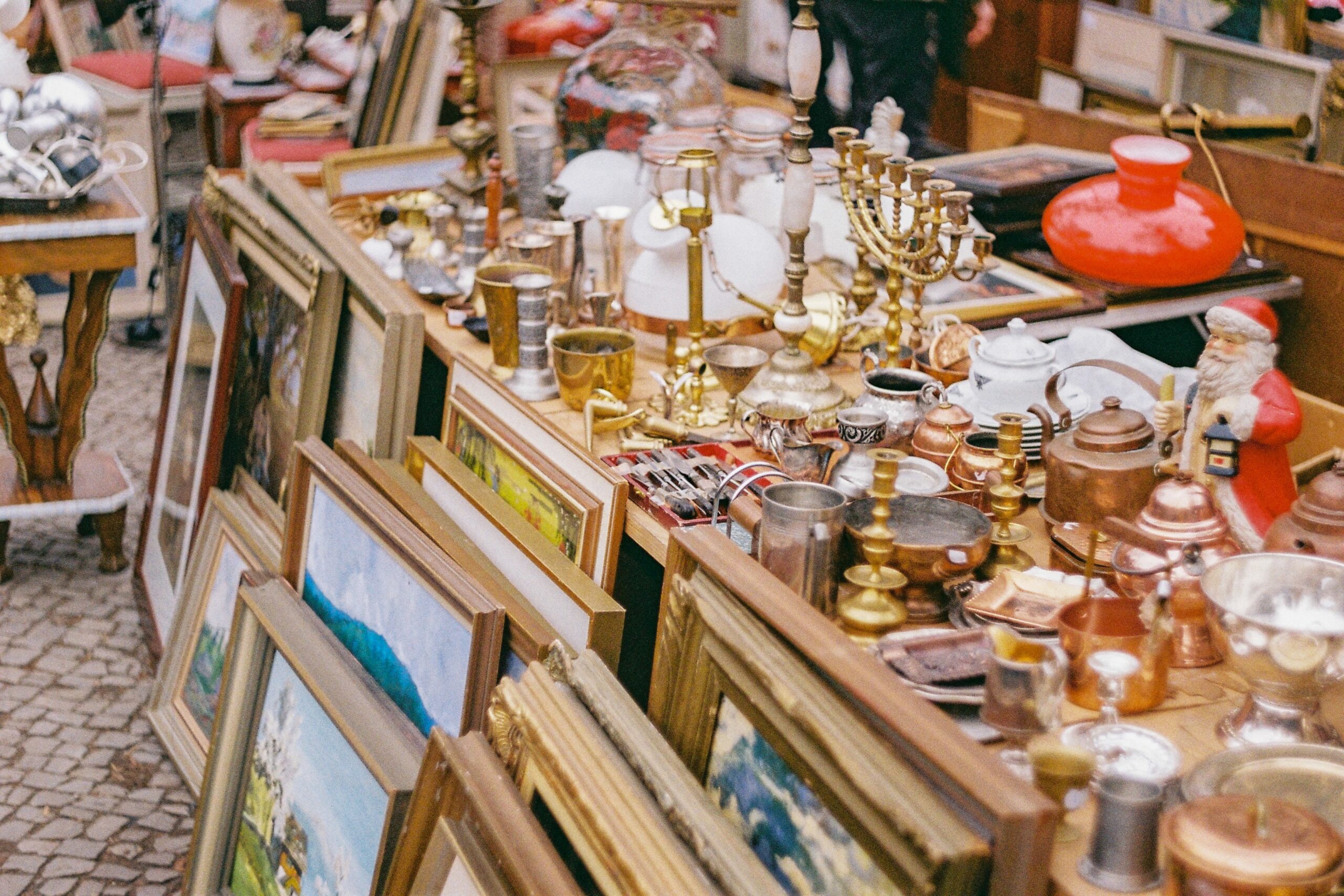 Bilder, lysestaker og andre gjenstander på et loppemarked. Foto