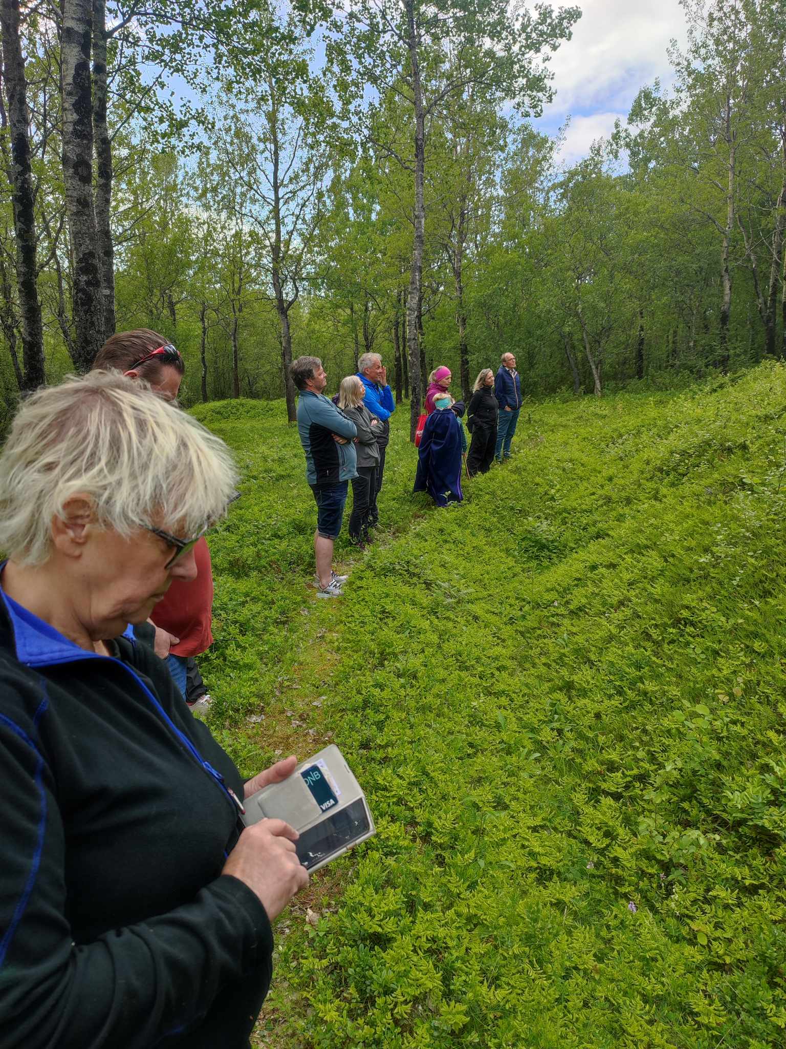 Bilde av folkemengde som står på en rekke i skogen.foto